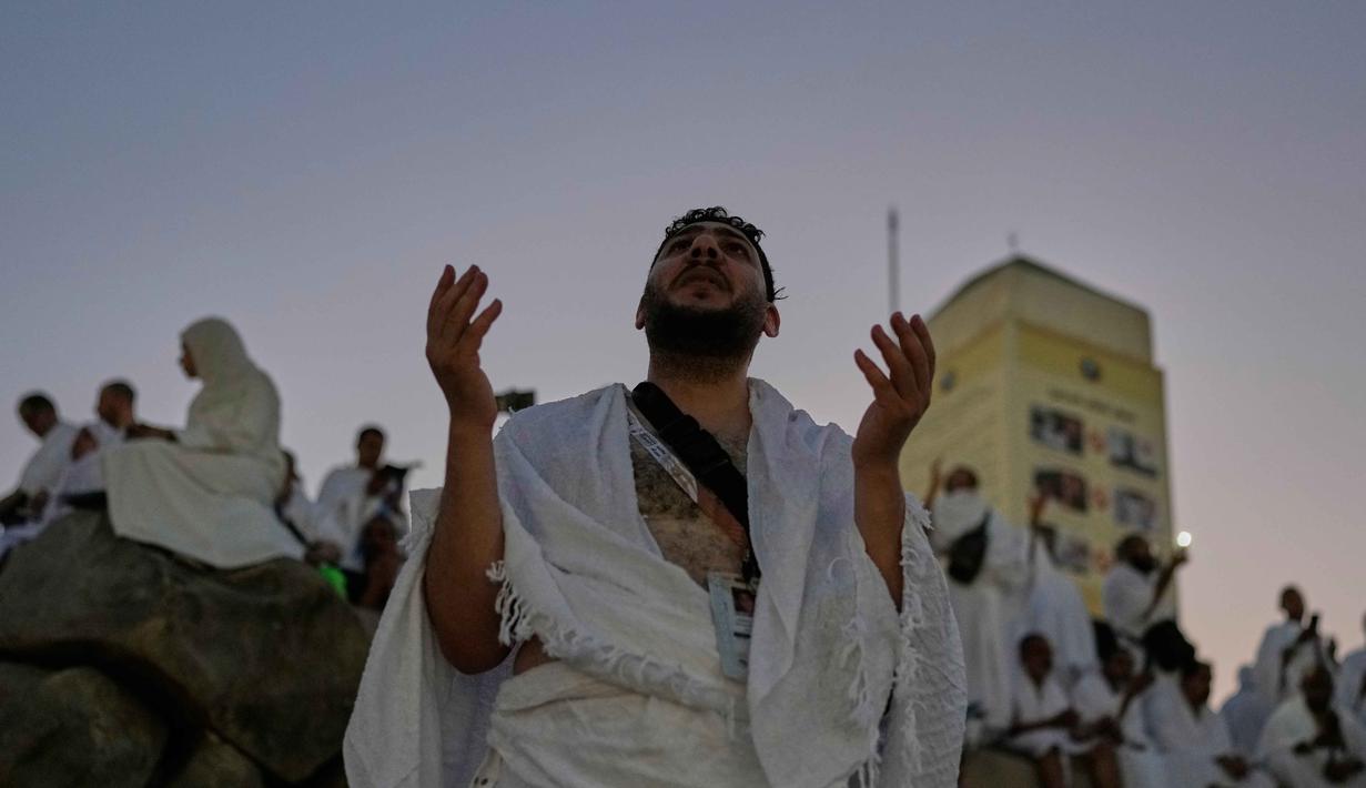 Seorang jemaah Muslim berdoa di puncak bukit berbatu yang dikenal sebagai Jabal Rahmah atau Gunung Rahmat, di Dataran Arafah, selama ibadah haji tahunan di dekat kota suci Mekah, Arab Saudi, Selasa 26 Mei 2026. (AP Photo/Altaf Qadri)