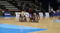 Atlet basket kursi roda Jepang, Rie Odajima (kiri), membantu atlet Afghanistan, Farzana Mohammadi, pada pertandingan Asian Para Games 2018 di Hall Basket Senayan, Senin (8/10/2018). (Asian Para Games 2018)