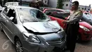 Petugas kepolisian menunjukkan mobil yang menabrak pejalan kaki di Jalan Boulevard Artha Gading, Jakarta, Sabtu (9/1/2016). Akibat kejadian tersebut, satu pengendara sepeda dan satu pejalan kaki meninggal di lokasi. (Liputan6.com/Helmi Afandi)