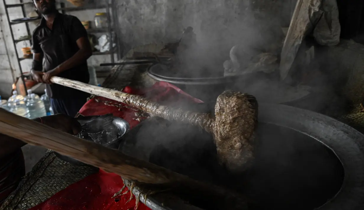 Koki katering menyiapkan hidangan bernama 'rebusan daging kambing Haleem' dalam peralatan besar untuk dijual kepada umat Muslim untuk berbuka puasa selama Ramadhan di Chennai (20/4/2022). Haleem adalah sajian favorit yang cukup populer, terutama saat bulan Ramadhan dan Muharram. (AFP/Arun Sankar)