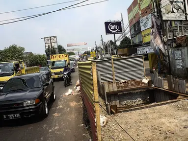 Sejumlah pengendara melintas di depan proyek galian sedalam 12 meter di Jalan Alternatif Cibubur, Jakarta, Senin (10/11/2014). (Liputan6.com/Faizal Fanani) 