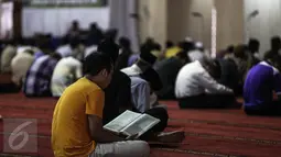 Seorang jamaah bertadarus pada hari pertama Ramadan 1437 H di Masjid Istiqlal, Jakarta, Senin (6/6). Bulan Ramadan, umat muslim memanfaatkan waktu memperbanyak ibadah dengan tadarus dan melaksanakan salat sunah. (Liputan6.com/Faizal Fanani)