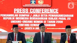 Direktur Jenderal Administrasi Hukum Umum (Dirjen AHU) Widodo (tengah) memberi keterangan terkait pengambilan sumpah dan janji setia pewarganegaraan Republik Indonesia empat atlet sepak bola putri di Kantor Kementerian Hukum, Jakarta, Selasa (10/6/2025). (Liputan6.com/Herman Zakharia)