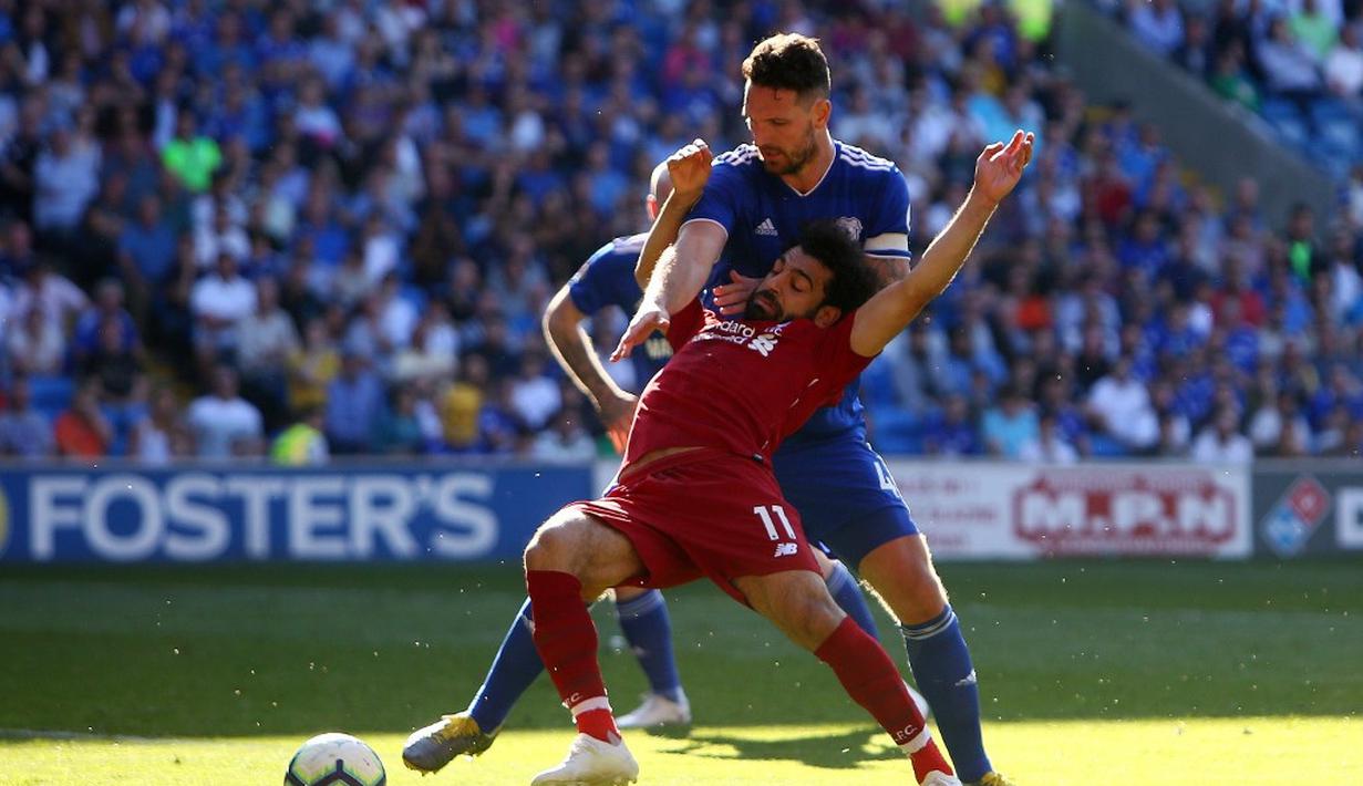 Mohammed Salah dilanggar oleh pemain Cardiff City, Sean Morrison pada laga lanjutan Premier League yang berlangsung di Stadion Millenium, Cardiff, Minggu (21/4). Liverpool menang 2-0 atas Cardiff City. (AFP/Geoff Caddick)