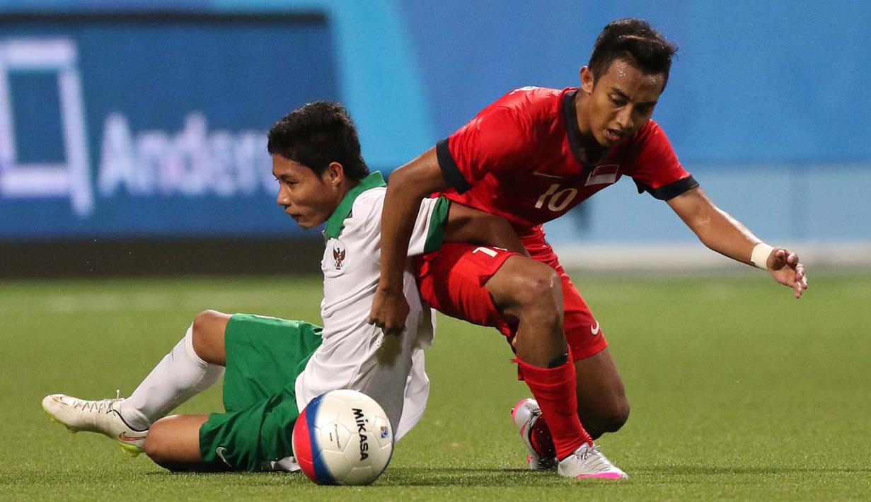 Pemain Indonesia U-23, Evan Dimas Darmono (kiri), berebut bola dengan pemain Singapura U-23, Muhammad Faris Ramli. (Bola.com/Arief Bagus)