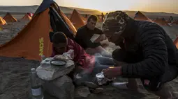 Para peserta mempersiapkan makan saat mengikuti lomba marathon sejauh 250 kilometer di Gurun Ica, Kamis (30/11/2017). Marathon yang terbagi dalam enam tahapan ini diprediksi akan berakhir pada 4 Desember. (AFP/Jean-Philippe Ksiazek)