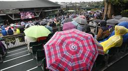 Warna-warni payung yang digunakan penonton saat menyaksikan laga tenis Wimbledon dari layar di The All England Lawn Tennis Club, London, (11/7/2017). (AP/Kirsty Wigglesworth)