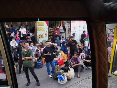Para calon penumpang menunggu bus yang akan mengangkut mereka menuju kampung halaman menjelang libur Idul Fitri 1447 Hijriah sekaligus menandai berakhirnya bulan suci puasa Ramadan, di terminal Terminal Kalideres, Jakarta, Rabu 18 Maret 2026. Puncak arus mudik Lebaran di Terminal Kalideres, Jakarta Barat, terlihat pada Rabu (18/3/2026). (AP Photo/Dita Alangkara)