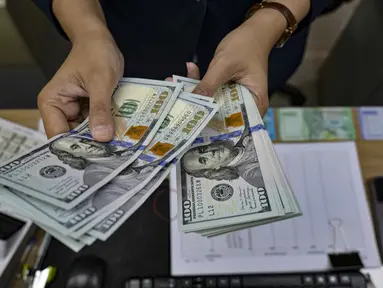 Seorang menghitung uang kertas Dolar AS di salah satu kantor penukaran uang, Jakarta, Selasa 12 Mei 2026. Nilai tukar rupiah terhadap dolar Amerika Serikat (USD) terpuruk pada perdagangan Selasa (12/5/2026). (BAY ISMOYO/AFP)