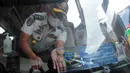 Petugas Dishub memasang stiker pada kaca  bus di Terminal Pulo Gebang, Jakarta, Selasa (4/5/2021). Jumlah penumpang yang berangkat dari Terminal Pulo Gebang terus meningkat jelang diberlakukannya aturan larangan mudik Lebaran mulai 6 Mei-17 Mei 2021. (Liputan6.com/Herman Zakharia)