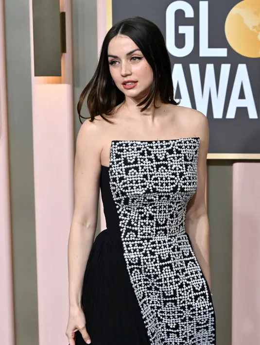 Ana de Armas tiba menghadiri Penghargaan Golden Globe Tahunan ke-80 di The Beverly Hilton di Beverly Hills, California (10/1/2023). Gaun strapless yang dikenakan Ana dirancang dengan kolom depan berhias kristal yang dibingkai oleh panel setinggi lantai untuk menciptakan siluet yang menawan. (Frederic J. Brown / AFP)
