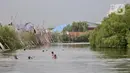 Anak-anak berenang di rawa pesisir Muara Baru, Cilincing, Jakarta, Minggu (15/8/2021). Anak-anak setempat memanfaatkan rawa sebagai wahana berenang akibat keterbatasan lahan bermain di wilayah pesisir tersebut. (merdeka.com/Iqbal S Nugroho)