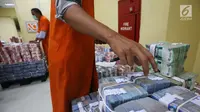 Petugas menata tumpukan uang kertas di Cash Center Bank BNI di Jakarta, Kamis (6/7). Nilai tukar rupiah terhadap dolar Amerika Serikat (USD) pada sesi I perdagangan hari ini masih tumbang di kisaran level Rp13.380/USD. (Liputan6.com/Angga Yuniar)