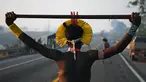 Masyarakat suku Kayapo memegang tongkat saat memblokir jalan raya utama Trans-Amazonian di Negara Bagian Para, Brasil (17/8/2020). Aksi tersebut dilakukan di tengah pandemi Covid-19 ini sebagai unjuk rasa adat. (AFP Photo/Carl De  Souza)