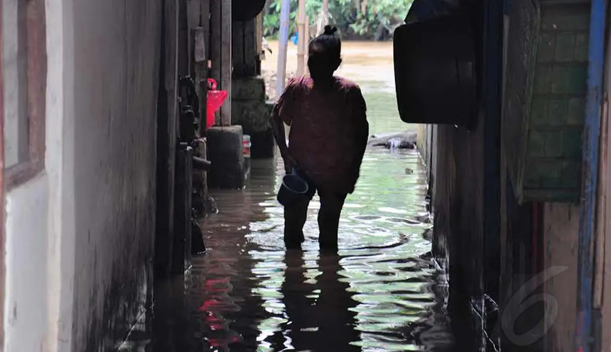Minggu (20/07/14) warga terpaksa harus bergelut dengan genangan air yang mengepung kawasan rumahnya di saat masyarakat tempat lain sedang menyiapkan hidangan untuk berbuka puasa (Liputan6.com/Faizal Fanani)