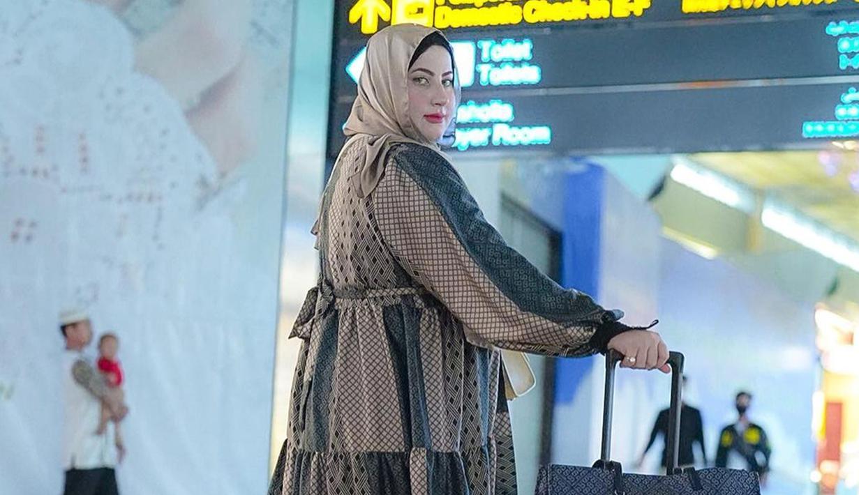 Tasyi Athasyia mengunggah momen keberangkatannya untuk menjalani umroh di media sosial. Dirinya terlihat tampil dengan busana gamis perpaduan warna cokelat dan detail hitam. (Liputan6.com/IG/@tasyiiathasyia)