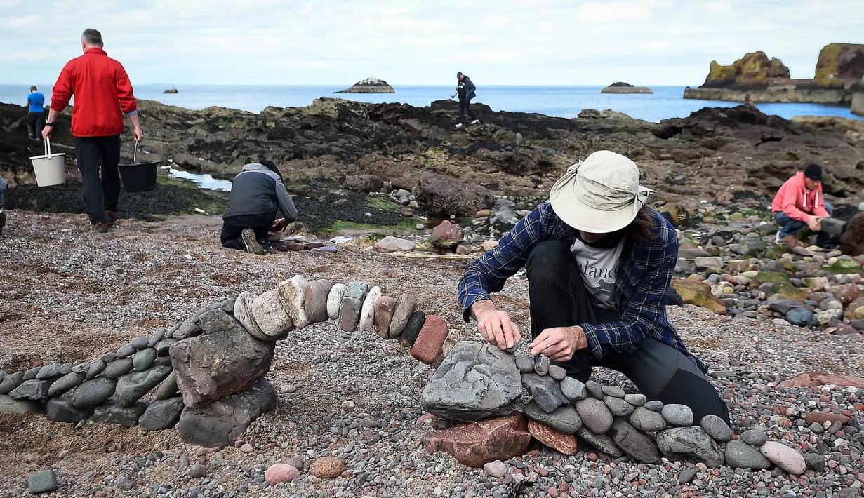Pedro Duran dari Spanyol membuat batu bertumpuk atau rock balancing dalam European Stone Stacking Championships 2018 di Dunbar, Skotlandia, Minggu (22/4). Kejuaraan ini diikuti seniman dan praktisi Stone Stacking dan Rock Balancing. (ANDY BUCHANAN/AFP)