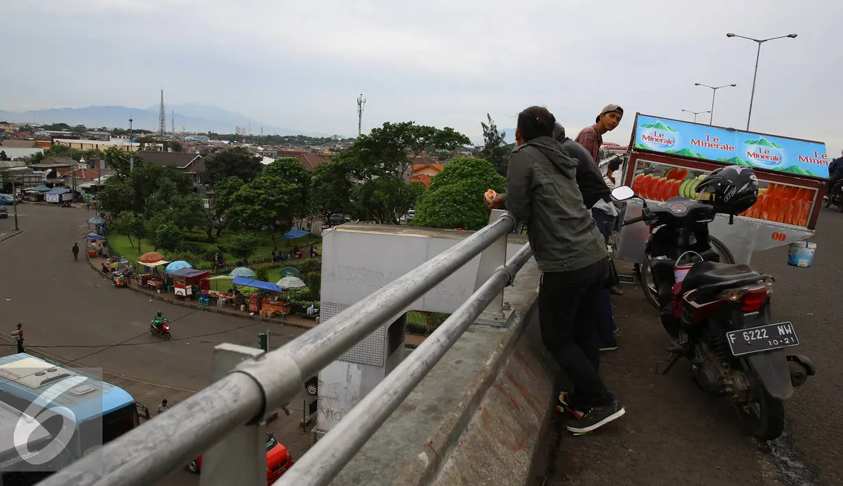 Pengendara sepeda motor menepikan kendaraannya di atas jalan layang Pasar Rebo, Jakarta, Sabtu (14/1). Padahal aktivitas tersebut berbahaya bagi keselamatan mereka serta pengendara lain. (Liputan6.com/Immanuel Antonius)