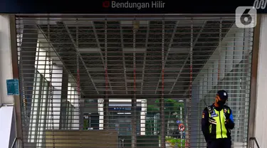 Petugas berjaga di depan pintu masuk menuju stasiun MRT Benhil, Jakarta, Selasa (29/4/2020). PT MRT Jakarta (Perseroda) menutup sementara layanan Stasiun Bendungan Hilir (Benhil) dan Stasiun Senayan sebagai bentuk dukungan penerapan pembatasan sosial berskala besar (PSBB). (Liputan6.com/Johan Tallo)