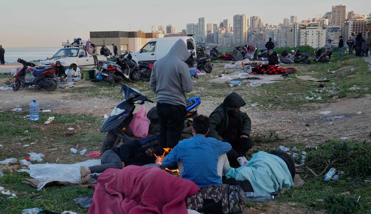 Serangan udara ini menyebabkan kehancuran bangunan permukiman dan asap tebal yang menyelimuti kota. Tampak dalam foto, para pengungsi yang melarikan diri dari serangan udara Israel di Dahiyeh, pinggiran selatan Beirut, tidur di tepi pantai Beirut, Lebanon, Jumat, 6 Maret 2026. (AP Photo/Hussein Malla)