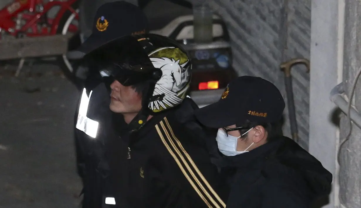 Pelaku pemenggal bocah perempuan (tengah) diamankan polisi ke Pusat Penahanan Taipei, Taiwan, Selasa (29/3). Pria itu memenggal kepala bocah tiga tahun dengan menggunakan pisau daging di hadapan ibu kandung bocah tersebut. (REUTERS/Tony HuangTAIWAN OUT)
