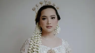 Paras cantik Rachel dirias flawless oleh MUA Jasmine Elishava. Dalam makeup tersebut menonjolkan bagian mata Rachel Amanda yang cantik. Kemudian bibirnya dipulas dengan pipi dan lipstik berwarna koral yang memberikan kesan elegan. (Liputan6.com/IG/@hibikiwedding)