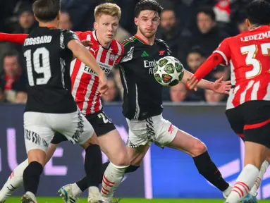Gelandang PSV Eindhoven Jerdy Schouten (tengah kiri) berebut bola dengan Declan Rice (Arsenal) saat leg pertama 16 besar Liga Champions 2024/2025 yang digelar di Philips Stadion, Eindhoven, pada tanggal 4 Maret 2025 waktu setempat atau Rabu (5/3/2025) dini hari WIB. (JOHN THYS/AFP)