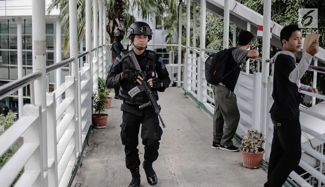 Seorang anggota Brimob bersenjata lengkap berjaga di JPO kawasan Bunderan HI, Jakarta, Jumat (11/5). Penjagaan tersebut dilakukan untuk antisipasi kegiatan Aksi 115 Pembebasan Baitul Maqdis yang berpusat di Monas. (Liputan6.com/Faizal Fanani)