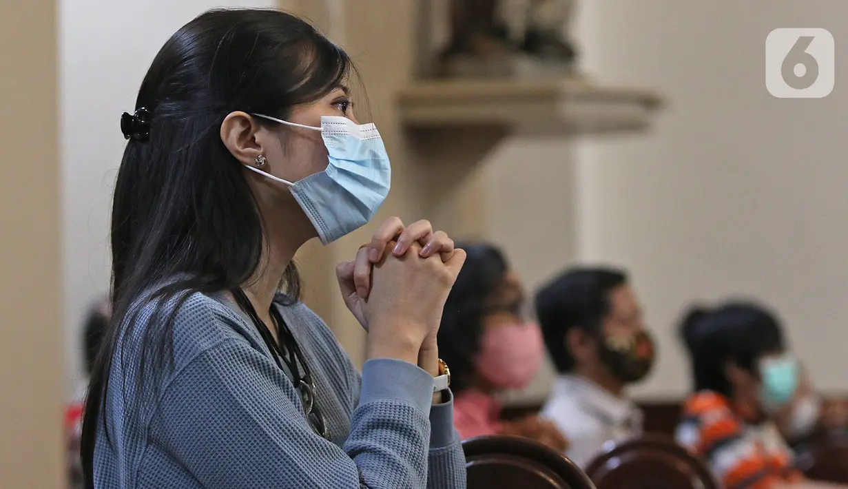 Jemaat umat kristiani berdoa saat melaksanakan Malam Misa Natal di Gereja Katedral Santo Petrus Bandung, Jawa Barat, Kamis (24/12/2020). Gereja membatasi jemaat yang hadir dalam pelaksanaan ibadah Natal maksimal 30 persen dari kapasitas ruangan ibadah. (Liputan6.com/Herman Zakharia)