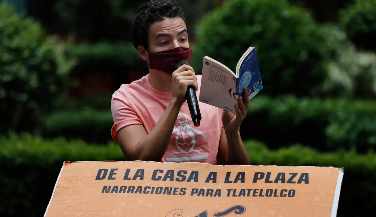 Percibald Garcia menggunakan mikrofon untuk membacakan cerita anak-anak di tengah-tengah kompleks perumahan Tlatelolco di Mexico City pada 18 Juli 2020. Lockdown akibat pandemi corona mmebuat arsitek muda berusia 27 tahun itu memutuskan untuk berbagi cerita menghibur anak-anak. (AP/Marco Ugarte)