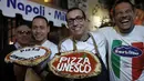 Pembuat piza (pizzaiuoli Neapolitan), Gino Sorbillo (tengah) bersama teman-temannya merayakan penetapan seni memutar adonan piza masuk ke dalam "kebudayaan tak terlihat" milik UNESCO di Naples, Italia, 7 Desember 2017. (AP Photo/Burhan Ozbilici)