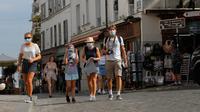Turis mengunjungi distrik Montmartre di Paris pada Senin (10/8/2020). Pemerintah Kota Paris mengumumkan masker wajib dipakai di area luar ruangan yang ramai di ibu kota Prancis itu mulai Senin (10/8) untuk mengendalikan peningkatan tingkat infeksi virus corona. (AP Photo/Michel Euler)