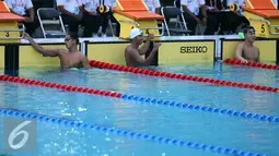 Perenang Jawa Barat, Triadi Fauzi S (kiri) melompat saat lomba di kelas 100m gaya bebas putra di Gelanggang Renang FPOK UPI, Bandung, Senin (19/9). Triadi meraih emas sekaligus memecahkan rekor PON dengan 50,49 dtk. (Liputan6.com/Helmi Fithriansyah)