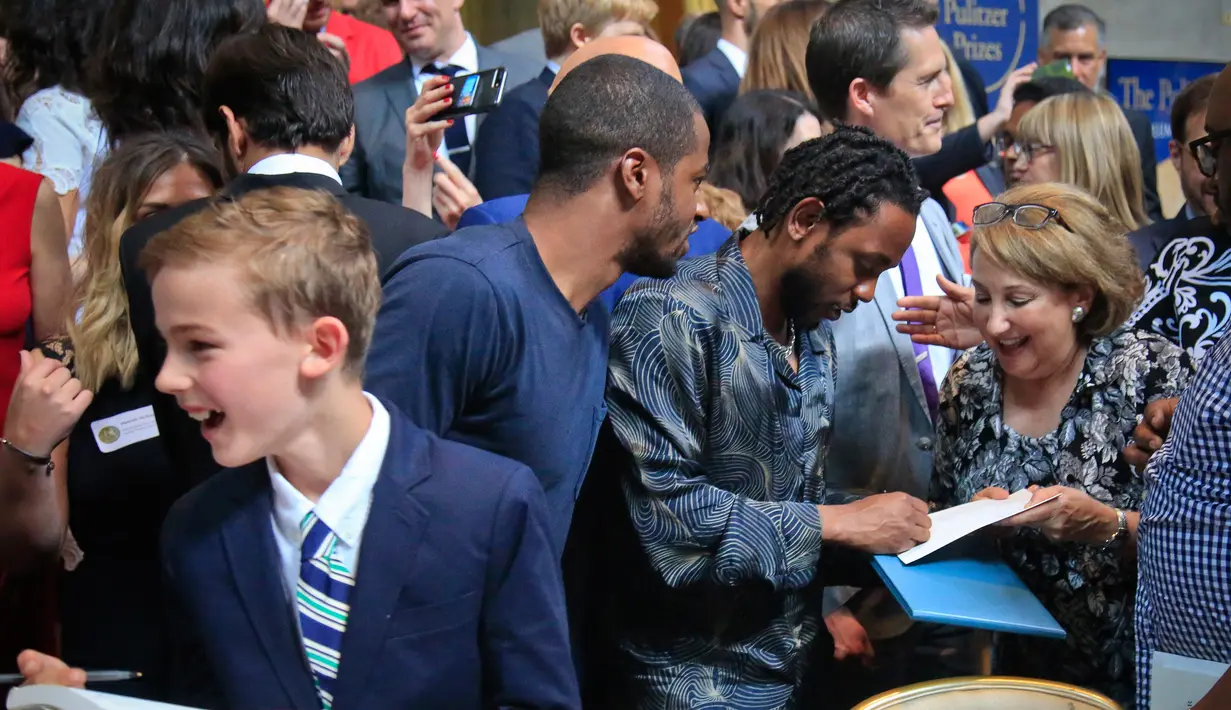 Rapper Kendrick Lamar memberi tanda tangan usai menerima penghargaan Pulitzer Prize 2018 di Universitas Columbia New York (30/5). Album Lamar dinilai sebagai koleksi lagu yang mempengaruhi kompleksitas kehidupan Afrika-Amerika modern. (AP/Bebeto Matthews)