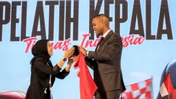 Pelatih kepala baru Timnas Indonesia, Patrick Kluivert mengambil peci yang disediakan oleh panitia setelah sesi konferensi pers yang berlangsung di Hotel Mulia, Senayan, Jakarta, Minggu (12/01/2025). (Bola.com/Bagaskara Lazuardi)