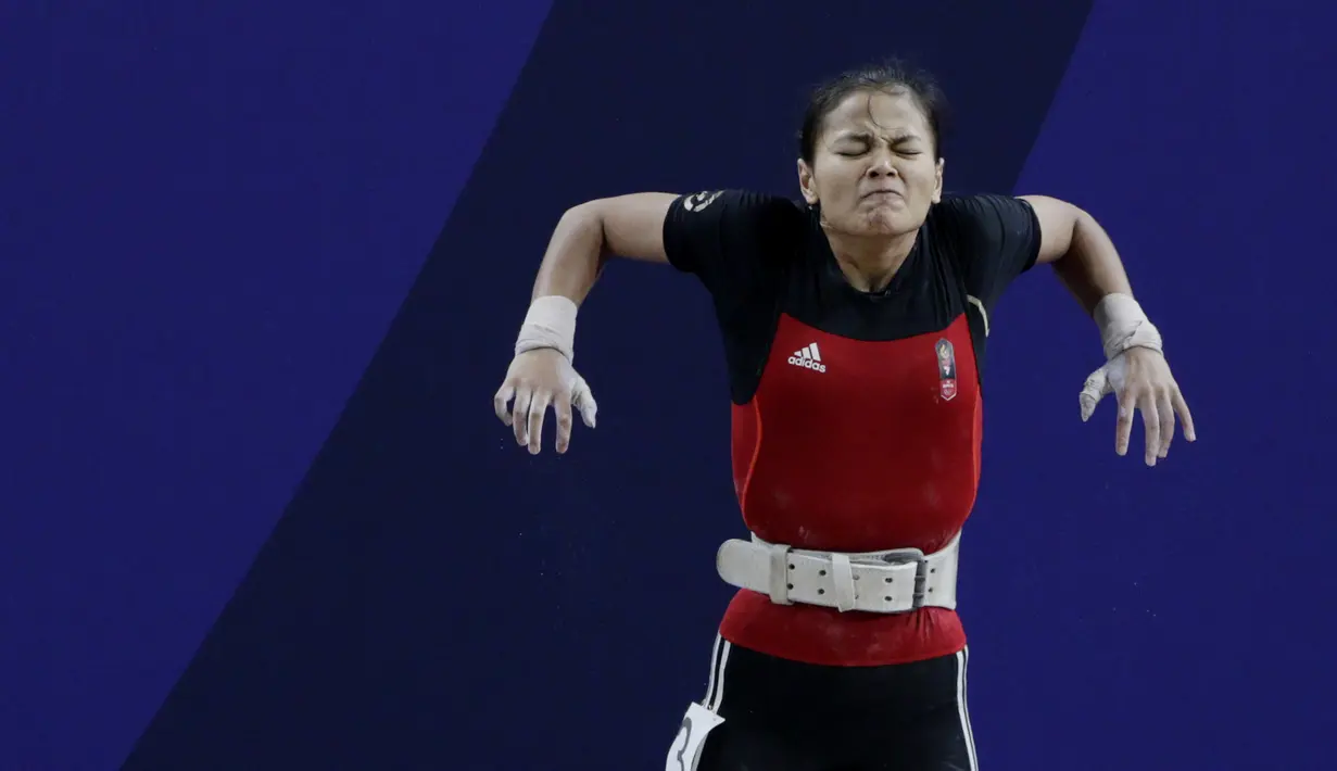 Lifter Windy Aisyah bersiap melakukan angkatan saat SEA Games 2019 cabang angkat besi nomor 49 kg di Stadion Rizal Memorial, Manila, Minggu (1/12). Dirinya meraih emas dengan total angkatan 104 kg. (Bola.com/M Iqbal Ichsan)