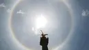 Fenomena halo matahari dengan latar depan monumen Malaikat Kemerdekaan di pusat kota Mexico City, Sabtu (7/7). Fenomena halo matahari terjadi karena pembiasan kristal es yang berada di sekitar Matahari yang membentuk semacam pelangi. (AP/Anthony Vazquez)