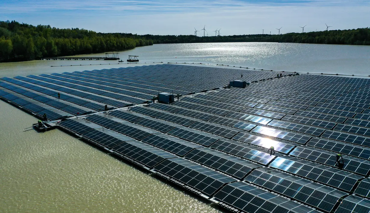 <p>Pemandangan dari udara menunjukkan Para pekerja merakit panel surya di pembangkit listrik fotovoltaik terapung di danau Silbersee di Haltern, Jerman barat (22/4/2022). Taman surya terapung ini akan menghasilkan hampir tiga juta kilowatt jam listrik per tahun. (AFP/Ina Fassbender)</p>