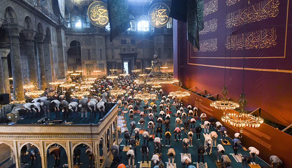 Jemaah mengenakan masker dan menerapkan jaga jarak untuk menghindari penularan COVID-19 saat melaksanakan salat Idul Adha di Hagia Sophia, Istanbul, Turki, Jumat (31/7/2020). Ini merupakan salat Idul Adha pertama di Hagia Sophia setelah dialihfungsikan dari museum menjadi masjid. (Pool via AP)