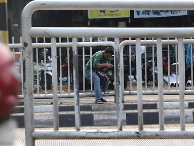 Seorang pria menerobos pagar pembatas jalan di kawasan Pasar Minggu, Jakarta, Kamis (5/4). Kondisi Jembatan Penyeberangan Orang (JPO) yang tak kunjung diperbaiki membuat warga nekat menyeberang lewat celah pagar pembatas. (Liputan6.com/Immanuel Antonius)