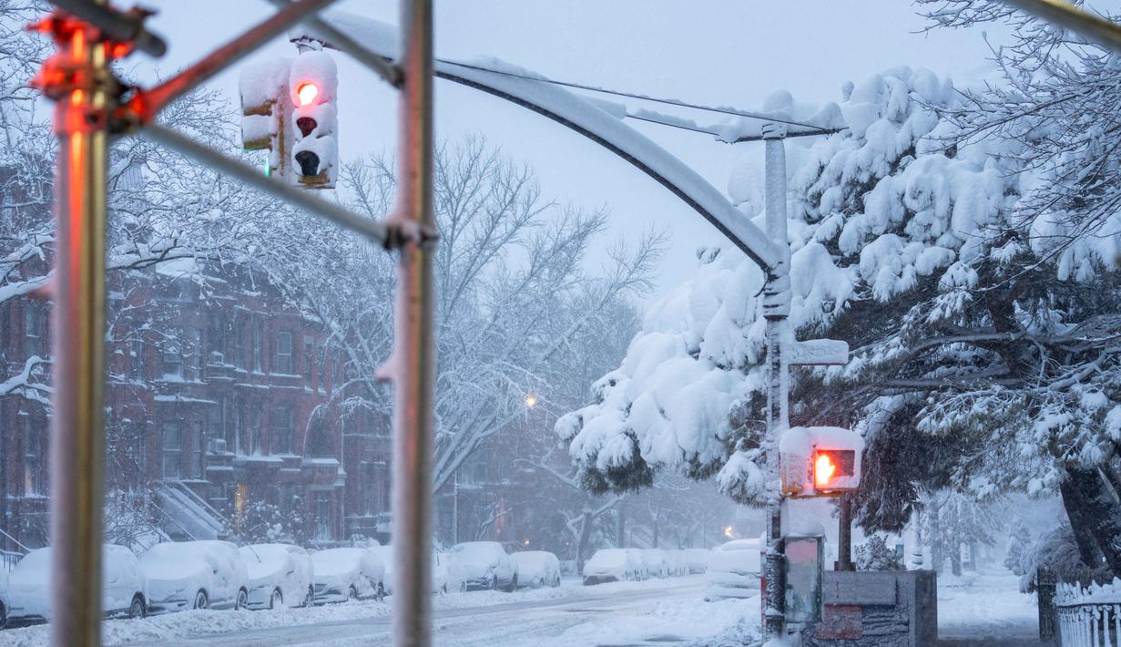 Sebagai informasi, kawasan Atlantik Tengah dan Timur Laut AS, mencakup New York, Pennsylvania, New Jersey, Delaware, Maryland, hingga Virginia Barat, merupakan urat nadi ekonomi dan pusat sejarah Amerika Serikat. Tampak dalam foto, salju menyelimuti jalanan dan trotoar di distrik Brooklyn, Kota New York, Senin 23 Februari 2026 pagi hari waktu setempat. (Jeremy Weine/Getty Images North America/Getty Images via AFP)