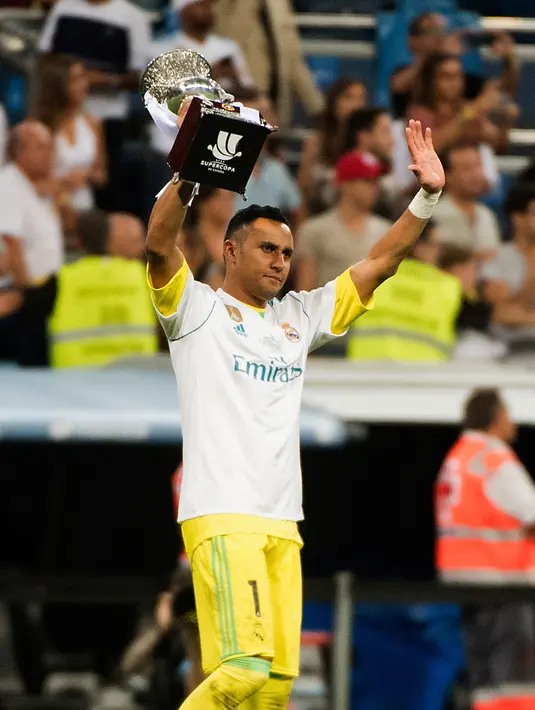 Kiper Real Madrid, Keylor Navas memegang trofi Piala Super Spanyol 2017 usai pertandingan melawan Barcelona di stadion Santiago Bernabeu, Spanyol (16/8). Real Madrid menang 2-0 atas Barcelona dengan skor agregat 5-1. (AFP Photo/Curto De La Torre)
