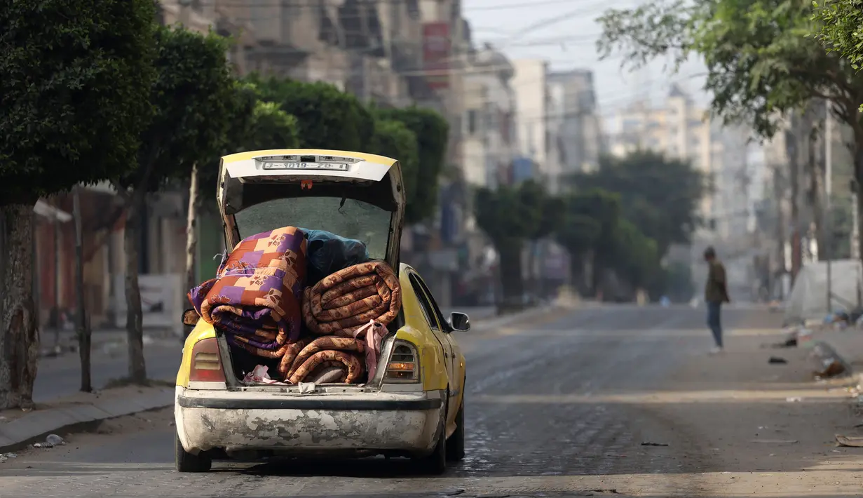 Sebuah mobil berisi kasur melaju di jalanan yang sepi di kota Gaza pada 11 Oktober 2023. (Mohammed ABED/AFP)