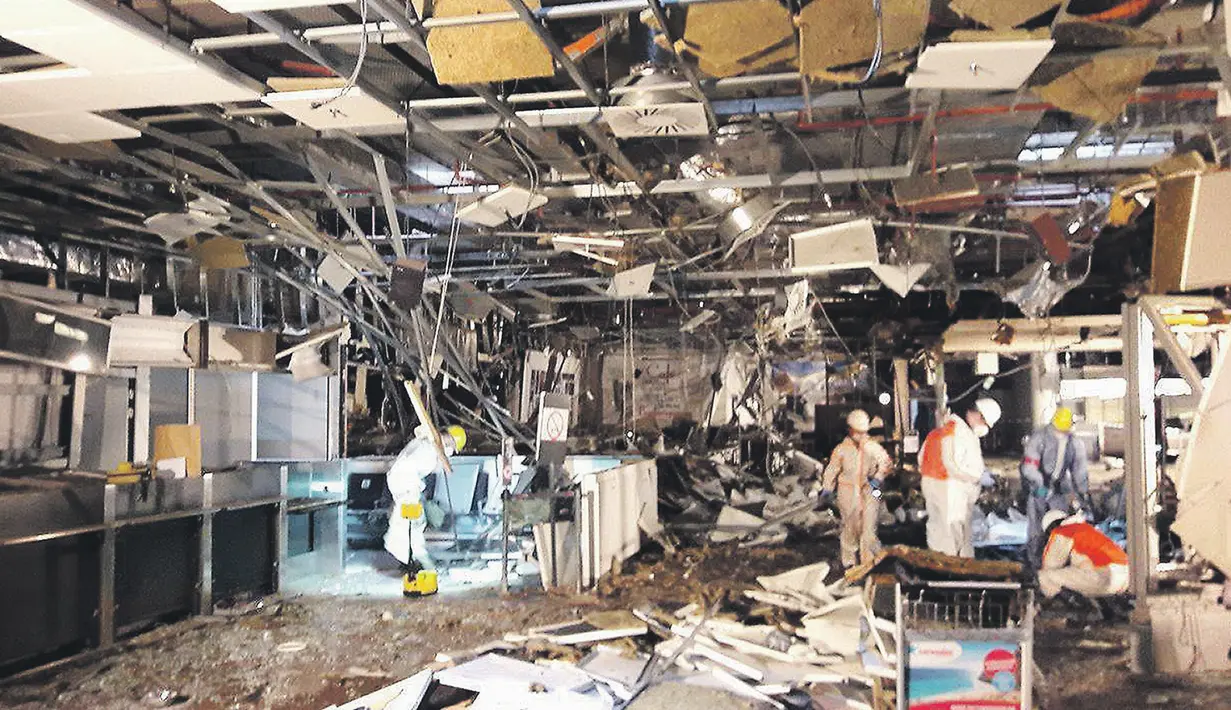 Petugas melakukan penyelidikan di dalam terminal keberangkatan yang rusak di bandara Zaventem, Brussels, Belgia, Selasa (29/3/2016). Ledakan bom kembar pada 22 Maret lalu menewaskan 14 korban. (Het Nieuwsblad via REUTERS)