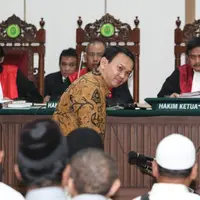 Basuki Tjahaja Purnama (Ahok) tersenyum saat akan duduk di kursi terdakwa untuk menjalani sidang keempat kasus dugaan penistaan agama di Gedung Auditorium Kementerian Pertanian, Jakarta, Selasa (3/1). (Liputan6.com/Dharma Wijayanto/Pool)