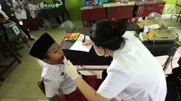 Siswa menjalani pemeriksaan gigi gratis di Mts Negeri 1, Batam, Kepri, Selasa (7/8). Pemeriksaan gigi gratis oleh mahasiswa Fakultas Kedokteran Gigi Trisakti digelar rangka HUT OT ke 70. (Liputan6/com/HO/Iwan)