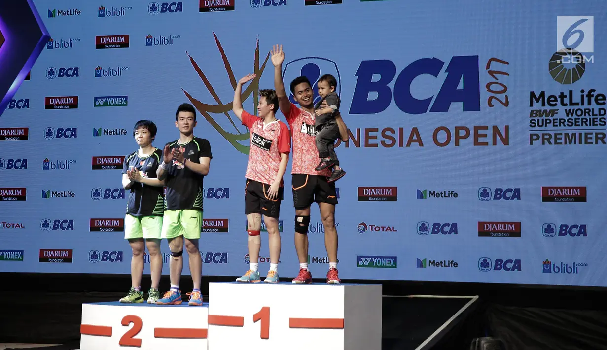 Ganda campuran Indonesia Tontowi Ahmad bersama anaknya dan Liliyana Natsir melambaikan tangan usai mengalahkan Ganda Campuran asal China Zheng Siwei/Chen Qingchen dalam final BCA Indonesia Open 2017 di Jakarta, Minggu (18/6). (Liputan6.com/Faizal Fanani)