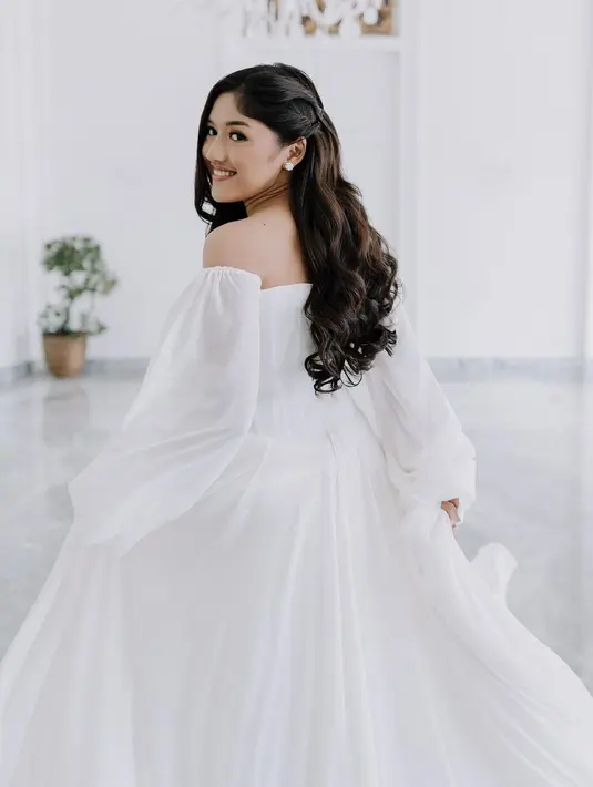 Gaun loose itu terlihat anggun dengan rambut Erina yang ditata dengan wave curly [@erinagudono]