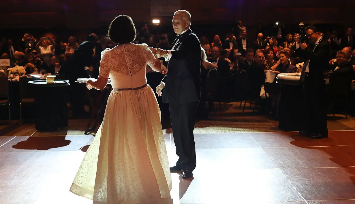 Mike Pence bersama istrinya, Karen Pence berdansa di Indiana Society Ball, Washington, DC. AS (19/1). Di Pemilu AS 2016 lalu, Donald Trump dan Mike Pence mengalahkan pasangan Hillary Clinton dan Tim Kaine. (Spencer Platt/Getty Images/AFP)