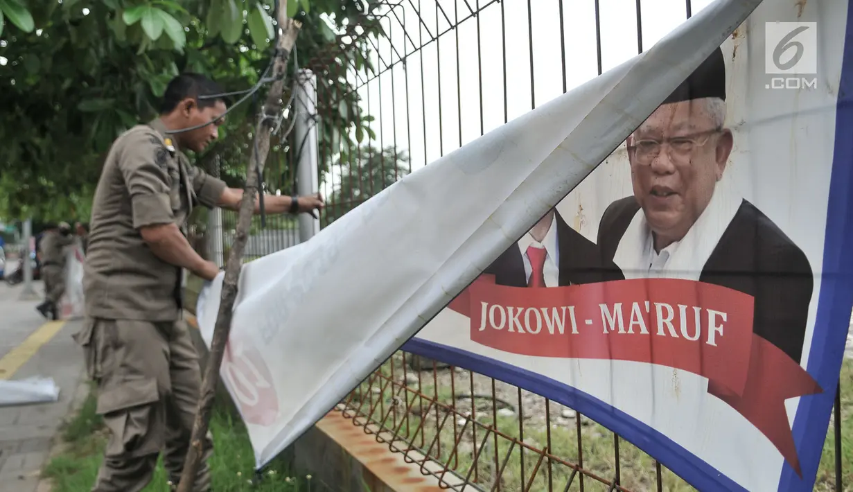Petugas Satpol PP mencopot spanduk APK di sepanjang Jalan Yos Sudarso, Jakarta Utara, Rabu (13/3). Bawaslu menginstruksikan Pemkot se-DKI Jakarta untuk menertibkan APK yang dipasang di sembarang tempat dan fasilitas umum. (merdeka.com/Iqbal S. Nugroho)